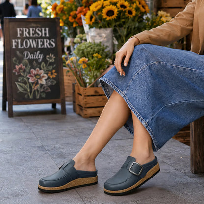Navy vegan leather clogs worn with a denim skirt outdoors