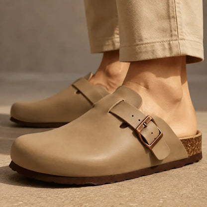 Tan smooth vegan leather mule clogs   worn with cream trousers, side view
