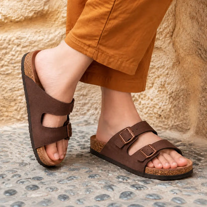 Dark brown suede double-buckle sandals worn outdoors with orange trousers