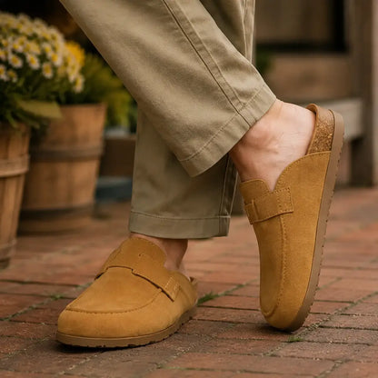 Camel suede loafer-style clog mules worn with khaki trousers